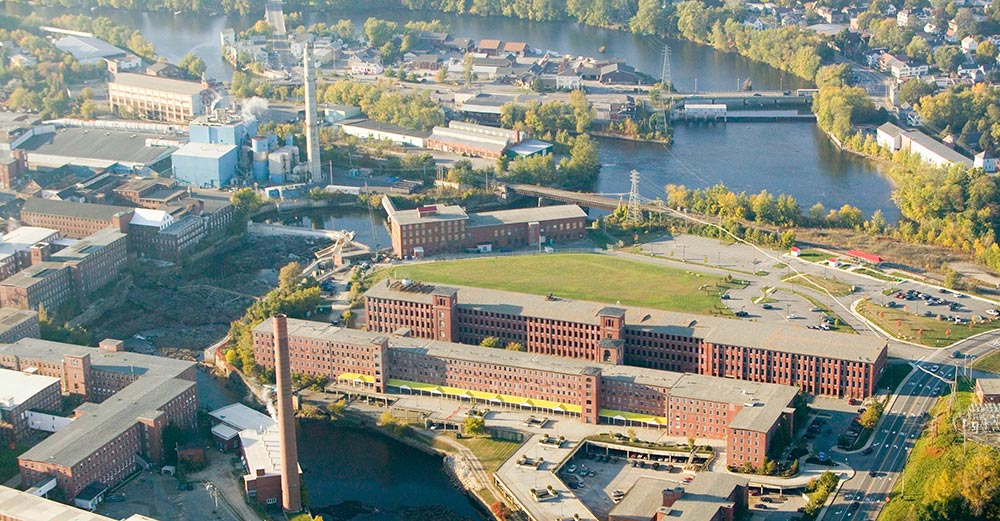 An aerial photo of historic brick buildings and smokestacks in an industrial area of Biddeford, Maine.