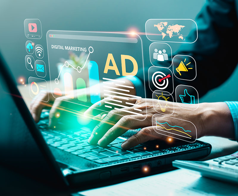 A person works at a laptop computer on a digital marketing and advertising campaign for business attraction