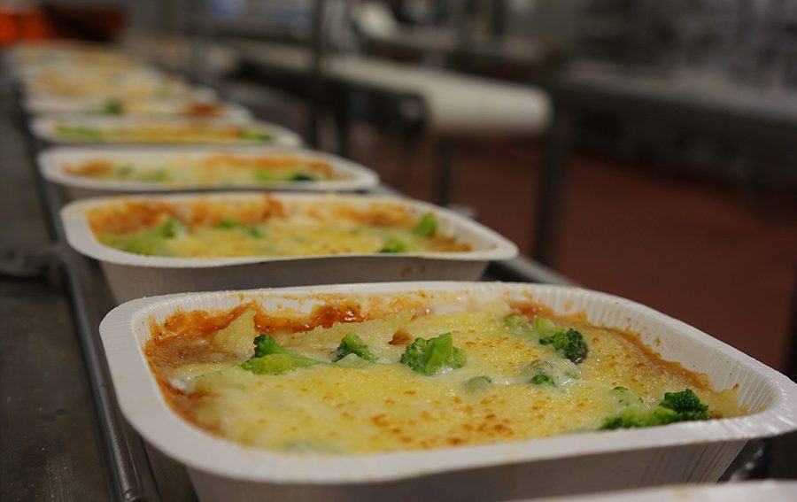 Trays of heat-and-eat dinners on a food production company conveyor belt