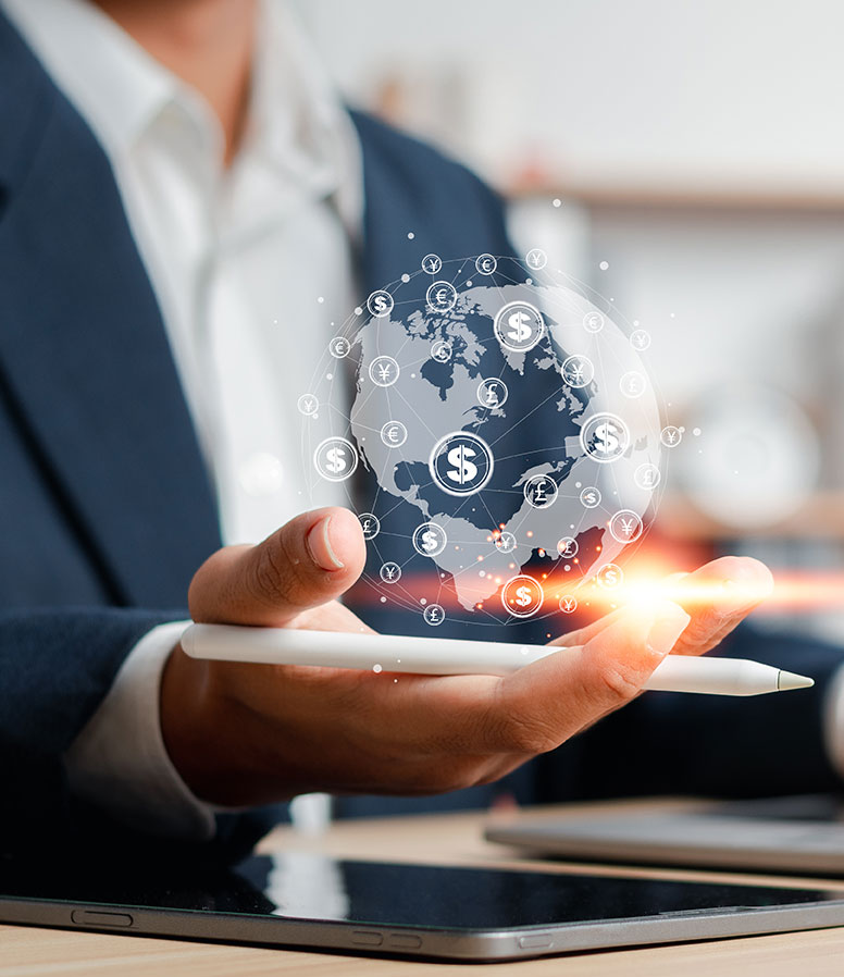 A man in suit holds an illustration of the Earth in his hand with symbols for different types of money on it