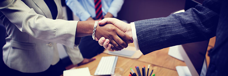 A man and woman shake hands at a business meeting