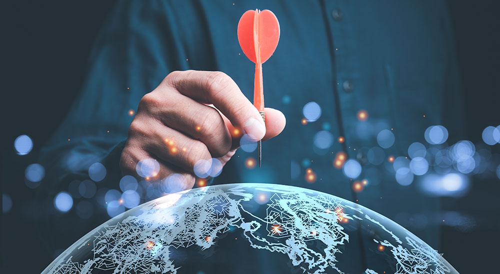 Business lead generation is illustrated by a person placing a red dark on a globe.