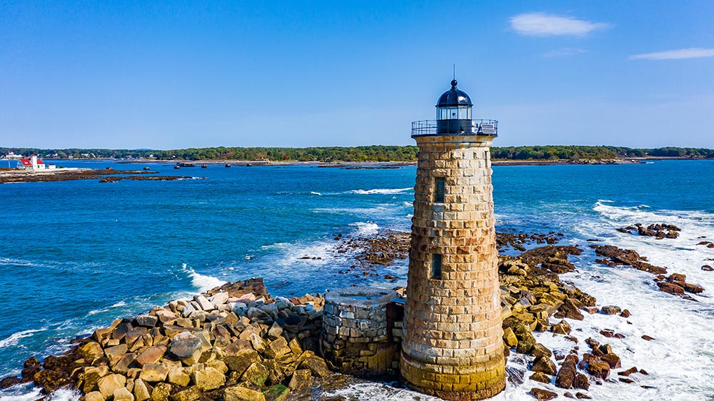 The Whaleback Lighthouse in Kittery, Maine, with the red-roofed Wood Island Life Saving Station in the background 