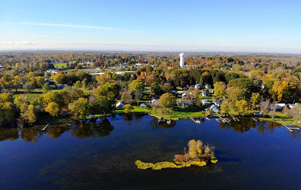 An aerial image of Oneida Lake in Oneida County, NY, with houses and a water tower around it